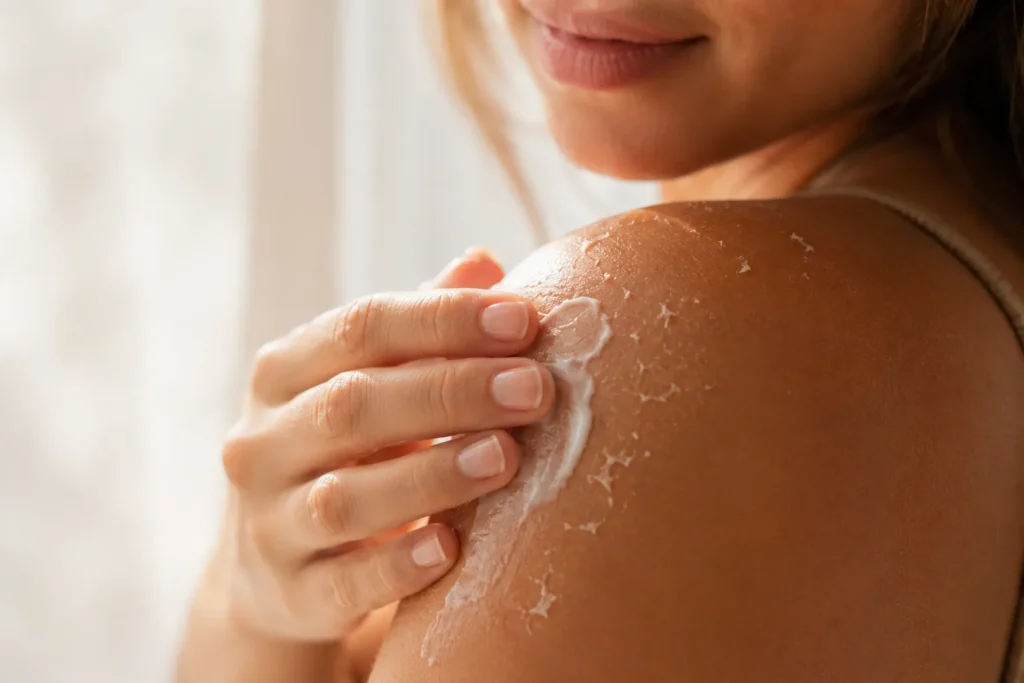 10 After Sun Mistakes That Can Harm Your Skin 4 Light skin peeling on shoulder being treated gently with soothing after sun lotion