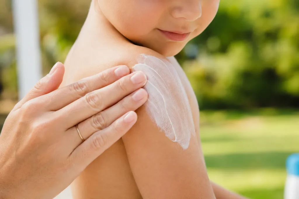 10 Kids Sunscreen Facts Every Parent Should Know 3 Mineral sunscreen being rubbed into a child's shoulder